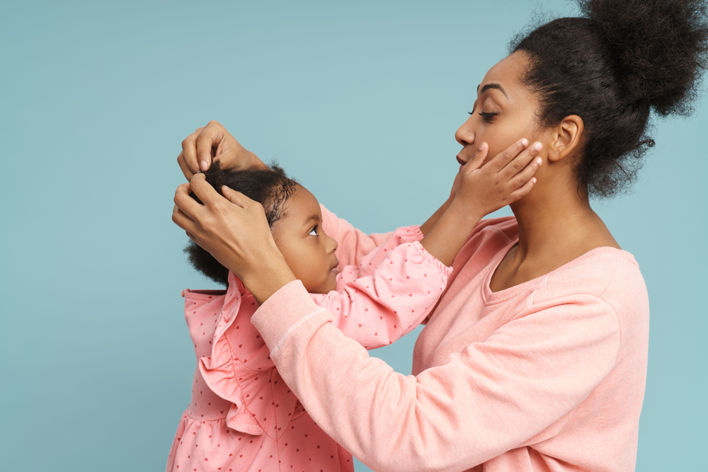 mom combing little gir's hair as she touches her face - a sign to be still- god hears her blog